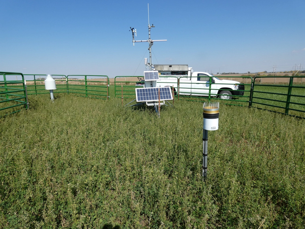 A sensor tower laden with weather measurement devices reaches upward toward a clear Nebraska sky.